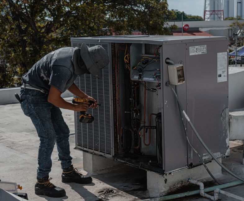 HVAC repair technician working on an air conditioning unit